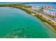 Beautiful view of the Intracoastal Waterway with buildings on the shore, lush trees, and vibrant turquoise waters at 460 S Paula Dr # 304, Dunedin, FL 34698