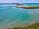 An aerial view of the ocean featuring beautiful beach and surrounding foliage at 460 S Paula Dr # 304, Dunedin, FL 34698