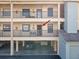 Exterior of condo showing the balcony, railing, parking garage underneath the building, and roof at 460 S Paula Dr # 304, Dunedin, FL 34698