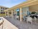 Pool-side lounge area with tables, chairs, and a mounted television at 460 S Paula Dr # 304, Dunedin, FL 34698