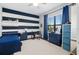 bedroom with blue and white striped accent wall, bright window, and wood flooring at 4609 Antrim Dr, Sarasota, FL 34240