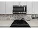 Close-up of the gourmet kitchen featuring sleek appliances, cooktop, and stylish backsplash at 4609 Antrim Dr, Sarasota, FL 34240