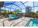 Screened-in patio with stone floor, plush lounge chairs, dining table, and a refreshing pool at 4609 Antrim Dr, Sarasota, FL 34240