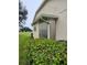 Beige exterior of a home with metal storm shutters, well-maintained landscaping, and a peek of the golf course at 5721 Cottonwood St, Bradenton, FL 34203