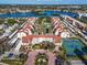 Aerial view of a community with a pool, tennis courts, waterway, and lush landscaping at 6263 Midnight Pass Rd # 105, Sarasota, FL 34242