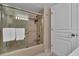 Bright bathroom featuring a shower-tub combination with sliding glass doors, complemented by neutral walls and white door at 6263 Midnight Pass Rd # 105, Sarasota, FL 34242