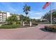 Inviting Excelsior community entrance with mature landscaping and an American flag waving in the breeze at 6263 Midnight Pass Rd # 105, Sarasota, FL 34242