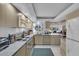Modern kitchen featuring white cabinetry, marble countertops, stainless appliances, and a view to the living area at 6263 Midnight Pass Rd # 105, Sarasota, FL 34242