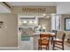 Bright kitchen with white cabinets, tile floors, bar seating, and 