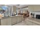 Bright kitchen with a view to the dining and living areas, light cabinets, and marble countertops at 6263 Midnight Pass Rd # 105, Sarasota, FL 34242