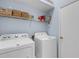 Laundry room includes a white washer and dryer with shelving for storage at 6326 Yellowtop Dr, Lakewood Ranch, FL 34202