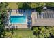 Aerial view of a backyard with a pool, patio, and mature tropical landscaping at 6650 Schooner Bay Cir # 6650, Sarasota, FL 34231