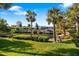 Waterfront property featuring a private boat dock with boat lift surrounded by palm trees and lush landscaping at 6650 Schooner Bay Cir # 6650, Sarasota, FL 34231