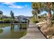 Private boat dock with a wooden walkway and space for mooring surrounded by beautiful landscaping and clear water at 6650 Schooner Bay Cir # 6650, Sarasota, FL 34231