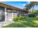 View of the screened-in patio with seating, surrounded by manicured landscaping and palm trees at 6650 Schooner Bay Cir # 6650, Sarasota, FL 34231