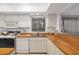 Bright kitchen featuring white cabinetry, butcher block countertops, and modern appliances at 6650 Schooner Bay Cir # 6650, Sarasota, FL 34231