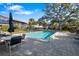 Community pool surrounded by chairs and tables, and large trees providing lots of shade at 6650 Schooner Bay Cir # 6650, Sarasota, FL 34231