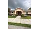 Charming peach colored clubhouse, lush landscaping, and inviting entrance at 6768 Breezy Palm Dr, Riverview, FL 33578