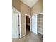 A hallway leading to the bathroom and walk-in closet with white doors and neutral paint at 6768 Breezy Palm Dr, Riverview, FL 33578