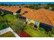 Aerial view of backyard with vibrant landscaping, screened-in lanai, and well-maintained lawn at 6907 Costa Bella Dr, Bradenton, FL 34209