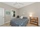 Neutral toned bedroom featuring a patterned bedspread, carpet, and a bright window at 6907 Costa Bella Dr, Bradenton, FL 34209