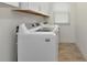 Laundry room featuring a washer and dryer, wood look tile flooring, and white cabinets at 6907 Costa Bella Dr, Bradenton, FL 34209