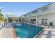 Large backyard swimming pool next to a white house with a covered patio and lounge seating at 7912 Desoto Memorial Hwy, Bradenton, FL 34209