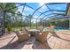 Outdoor pool area with screened enclosure and brick flooring featuring ample seating space at 8248 Larkspur Cir, Sarasota, FL 34241