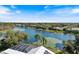Beautiful aerial view of a home near a calm lake with lily pads and palm trees under a blue sky at 8579 Woodbriar Dr, Sarasota, FL 34238