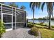 Backyard of home featuring screen enclosed lanai overlooking lake at 8579 Woodbriar Dr, Sarasota, FL 34238
