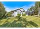 Lush backyard featuring a screened lanai, well-manicured lawn, and beautiful landscaping at 8579 Woodbriar Dr, Sarasota, FL 34238
