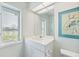 Bright bathroom with a white vanity, large mirror, and a window offering a picturesque lake view at 8579 Woodbriar Dr, Sarasota, FL 34238