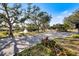 Picturesque gated community entrance with a fountain, lush landscaping, and mature trees on a sunny day in Sarasota, Florida at 8579 Woodbriar Dr, Sarasota, FL 34238