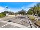 Paved entrance road lined with manicured lawns, mature trees, and a decorative privacy wall at 8579 Woodbriar Dr, Sarasota, FL 34238