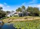 Beautiful home overlooking a serene pond, featuring a screened-in pool and meticulous landscaping at 8579 Woodbriar Dr, Sarasota, FL 34238
