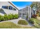 Backyard of home featuring screen enclosed lanai with tropical plants and landscaping at 8579 Woodbriar Dr, Sarasota, FL 34238