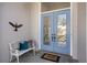 Close-up of an elegant blue front door with decorative glass inserts and a cozy bench nearby at 8579 Woodbriar Dr, Sarasota, FL 34238
