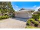 Spacious two-car garage with a paved driveway and well-manicured landscaping at 8579 Woodbriar Dr, Sarasota, FL 34238