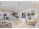 Open-concept living room with neutral decor, tile flooring, and sliding glass doors to lanai at 8579 Woodbriar Dr, Sarasota, FL 34238
