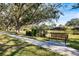 Scenic view of a park bench overlooking a pond with lush landscaping, trees, and walking path in Sarasota, Florida at 8579 Woodbriar Dr, Sarasota, FL 34238