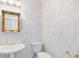 Elegant powder room with pedestal sink and decorative mirror, great for guests at 8579 Woodbriar Dr, Sarasota, FL 34238