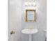 Elegant powder room with pedestal sink and decorative mirror, great for guests at 8579 Woodbriar Dr, Sarasota, FL 34238
