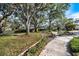 A peaceful park with a walking path, mature trees, and a bench provides a serene environment in Sarasota, Florida at 8579 Woodbriar Dr, Sarasota, FL 34238