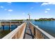 Scenic view of a wooden dock extending into calm waters, surrounded by lush landscaping and homes at 1200 E Peppertree Ln # 305, Sarasota, FL 34242