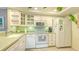 Bright kitchen showcasing white appliances, white cabinets, and light green countertop at 1200 E Peppertree Ln # 305, Sarasota, FL 34242