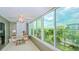 The sunroom features abundant natural light and views of the surrounding cityscape and lush greenery at 1200 E Peppertree Ln # 305, Sarasota, FL 34242