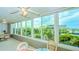 Bright sunroom with floor to ceiling windows boasting panoramic views of tropical greenery and buildings at 1200 E Peppertree Ln # 305, Sarasota, FL 34242