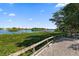 Scenic waterfront with lush landscaping, wooden fencing, and glimpses of luxurious waterfront homes at 1200 E Peppertree Ln # 305, Sarasota, FL 34242