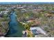 Stunning aerial view of a waterfront home featuring a private pool and boat dock, surrounded by lush landscape at 1240 Northport Dr, Sarasota, FL 34242