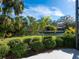 Beautiful backyard with a tranquil canal view, lush landscaping, and a vibrant blue sky at 1240 Northport Dr, Sarasota, FL 34242